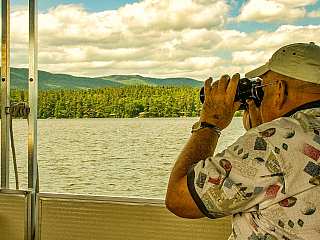 Viewing wildlife through binoculars on a Squam Lake Cruise